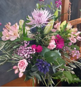 Centro floral en tonos rosas y morados